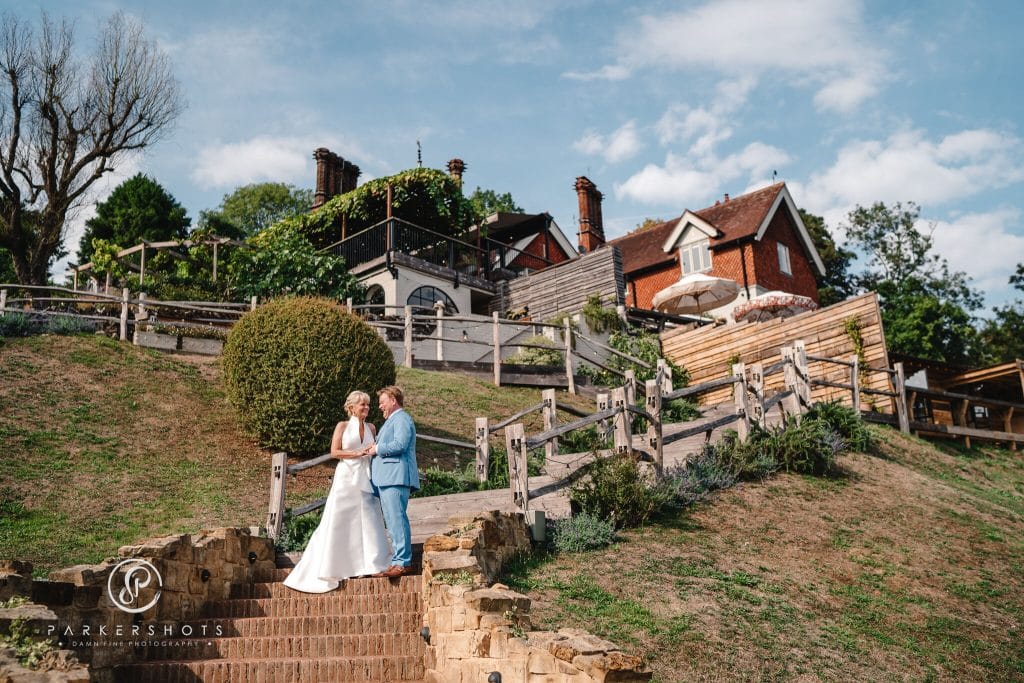 Wedding photography of bride and groom at The Beacon in Tunbridge Wells with the bride and groom on the stairs leading up to the main building