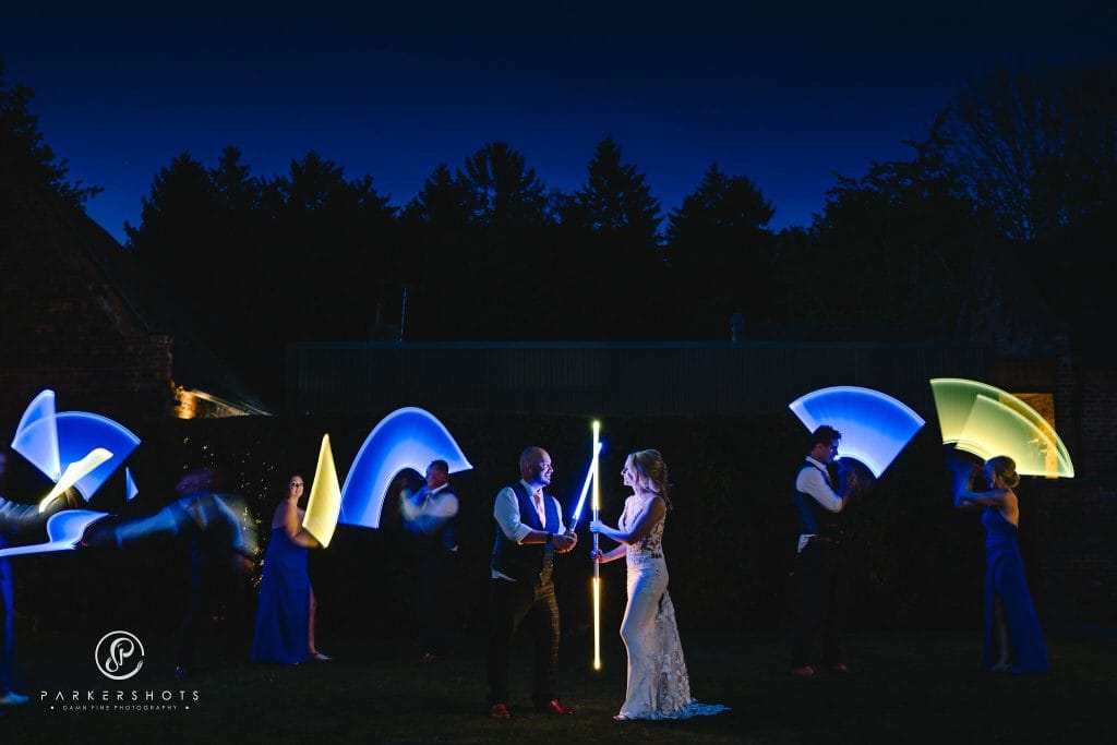Wedding Photography at Shustoke Barn with bride and groom & their wedding party battling with lightsabers