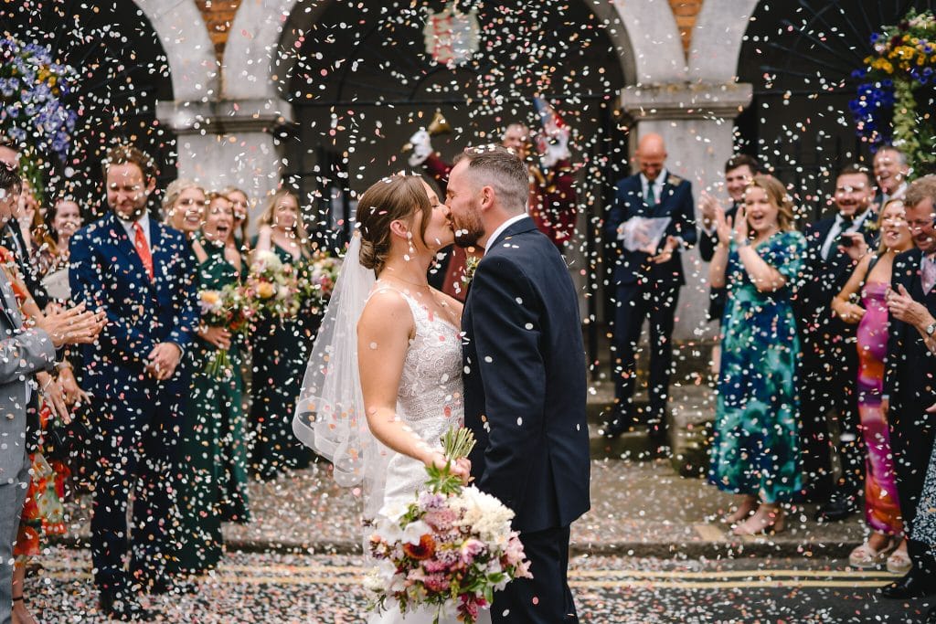 Photo of bride and groom being covered in confetti outside Rye Town Hall in Sussex