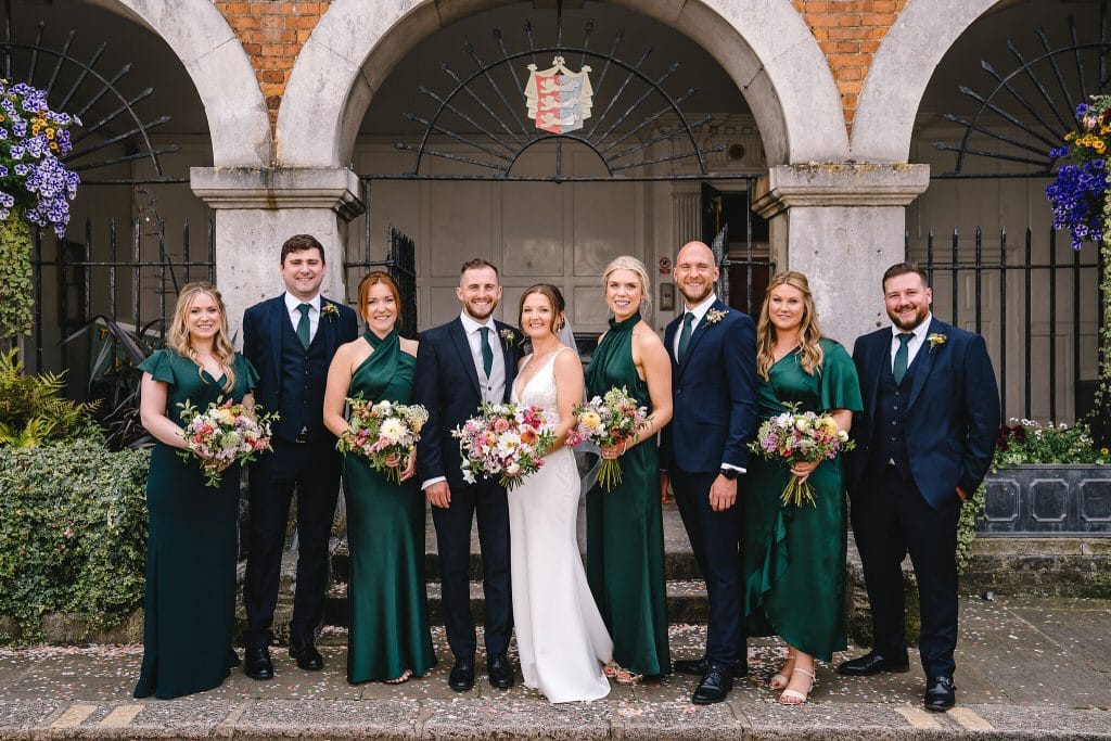 The bride and groom with their bridesmaids and groomsmen outside Rye Town Hall by Sussex Wedding Photographer, Parkershots