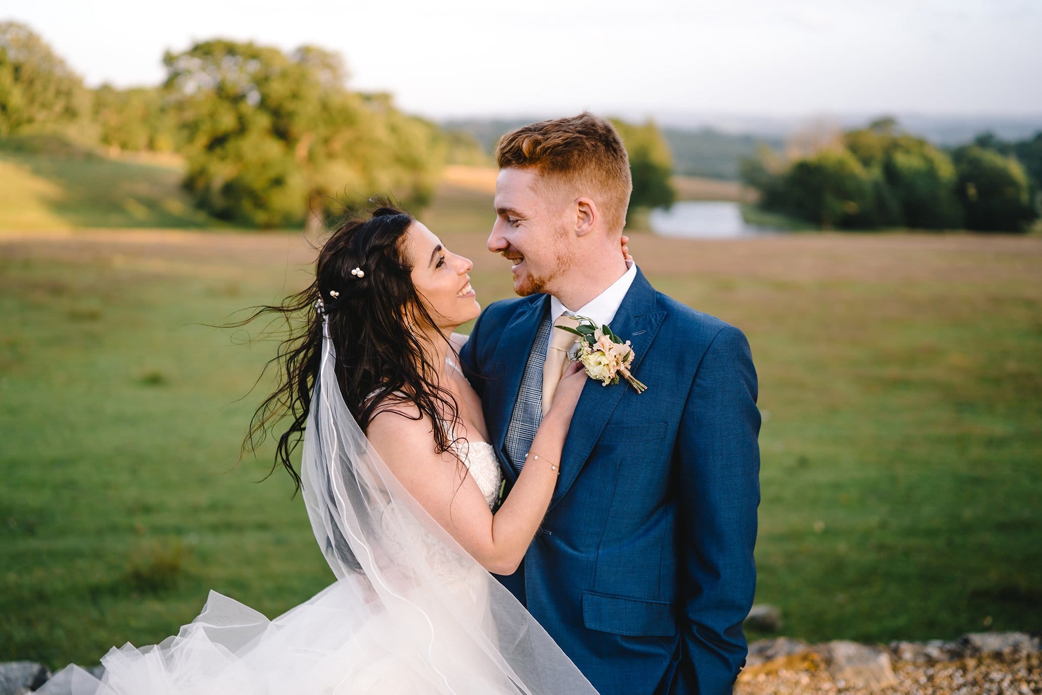 wedding photography at Wadhurst Castle of bride and groom embracing on a windy day
