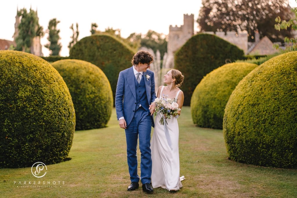 Wedding Photograph from Penshurst Place from Anna & Harry's wedding by Parkershots. Image shows couple walking in gardens