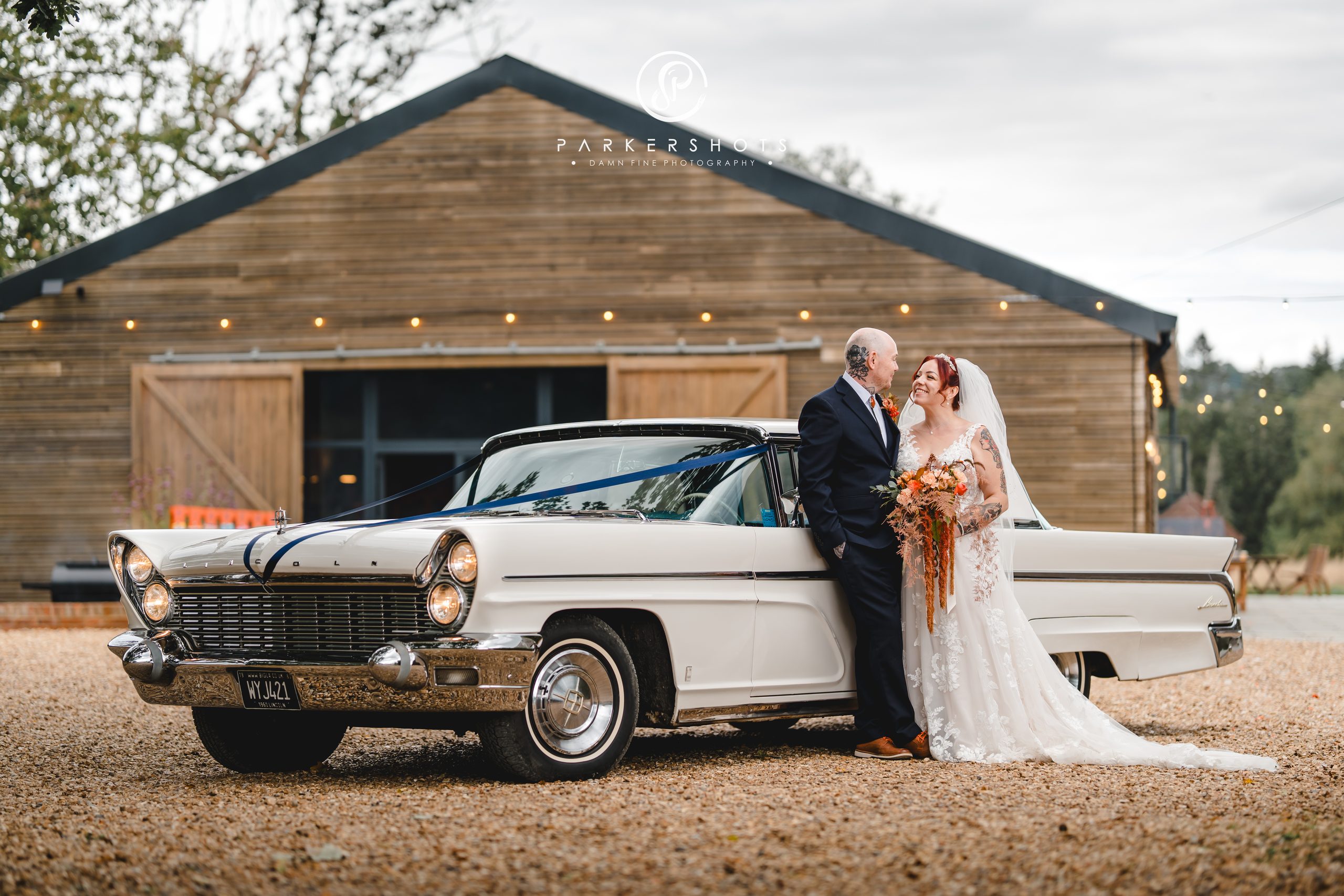 Wedding photography from Holly & Josh's wedding at Chafford Park with them standing by a beautiful american car, a Lincoln Premier